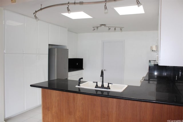 155 Polihale Pl, Honolulu, HI 96825 - kitchen with a sink, freestanding refrigerator, dark countertops, white cabinets, and a peninsula