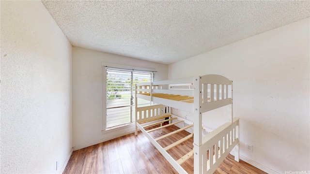 92-1244 Kikaha St Unit 14, Kapolei, HI 96707 - unfurnished bedroom with wood finished floors, a textured ceiling, and baseboards