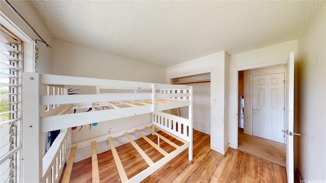 92-1244 Kikaha St Unit 14, Kapolei, HI 96707 - unfurnished bedroom featuring wood finished floors, a textured ceiling, a closet, and baseboards
