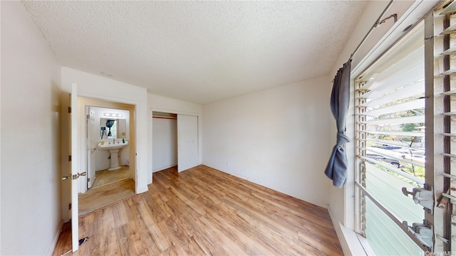 92-1244 Kikaha St Unit 14, Kapolei, HI 96707 - unfurnished bedroom with light wood finished floors, a textured ceiling, and a closet