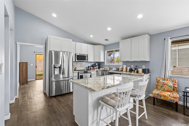 94-1106 Kaloli Loop, Waipahu, HI 96797 - kitchen with appliances with stainless steel finishes, a sink, a kitchen breakfast bar, lofted ceiling, and dark wood finished floors