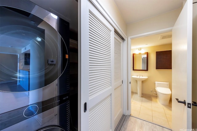 1551 Ala Wai Blvd Unit 2903, Honolulu, HI 96815 - washroom with a sink, baseboards, tile patterned flooring, stacked washer and dryer, and laundry area