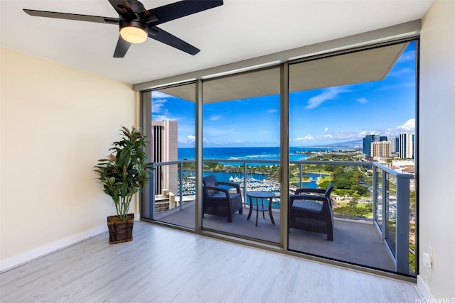 1551 Ala Wai Blvd Unit 2903, Honolulu, HI 96815 - unfurnished room with wood finished floors, a water view, a ceiling fan, a wall of windows, and baseboards