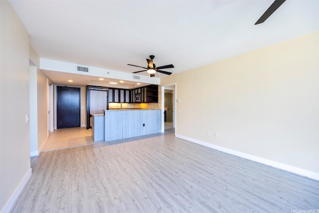 1551 Ala Wai Blvd Unit 2903, Honolulu, HI 96815 - unfurnished living room featuring ceiling fan, baseboards, visible vents, and light wood-style flooring
