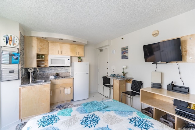 134 Kapahulu Ave Unit 617, Honolulu, HI 96815 - kitchen featuring white appliances, light brown cabinetry, backsplash, a sink, and a textured ceiling