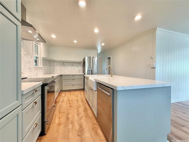 47-104 Hunaahi St, Kaneohe, HI 96744 - kitchen with stainless steel appliances, gray cabinetry, wall chimney exhaust hood, light wood-type flooring, and a kitchen island with sink