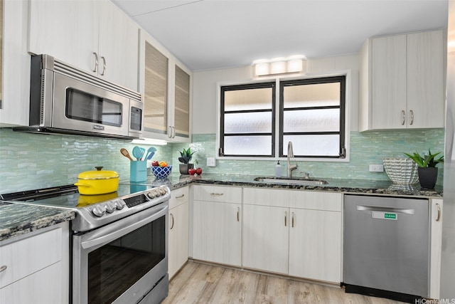 1230 Hoohulu St, Pearl City, HI 96782 - kitchen with stainless steel appliances, dark stone counters, backsplash, glass insert cabinets, and light wood-type flooring