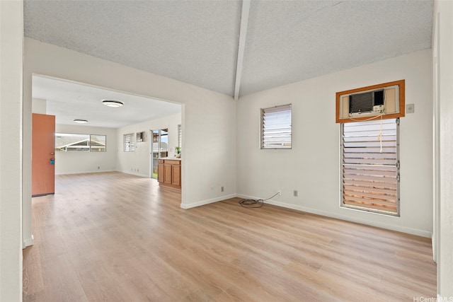 94-441 Kauopua St, Mililani, HI 96789 - unfurnished dining area with a wall unit AC, light wood finished floors, plenty of natural light, baseboards, and a textured ceiling