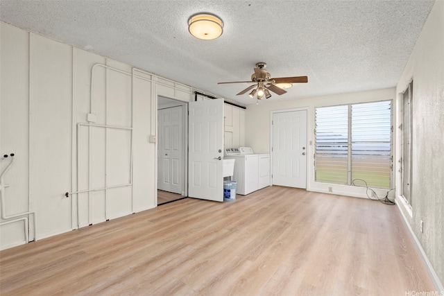 94-441 Kauopua St, Mililani, HI 96789 - unfurnished bedroom with independent washer and dryer, light wood-type flooring, a textured ceiling, and multiple closets
