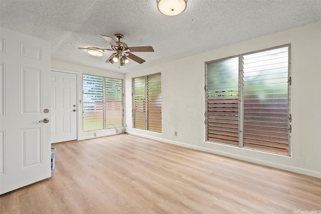 94-441 Kauopua St, Mililani, HI 96789 - empty room featuring light wood-style flooring, a textured ceiling, ceiling fan, and baseboards