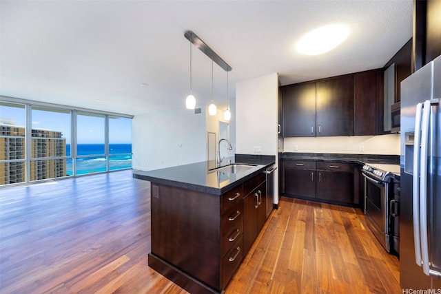 1189 Waimanu St Unit 2803, Honolulu, HI 96814 - kitchen with stainless steel appliances, a sink, dark countertops, wood finished floors, and a peninsula