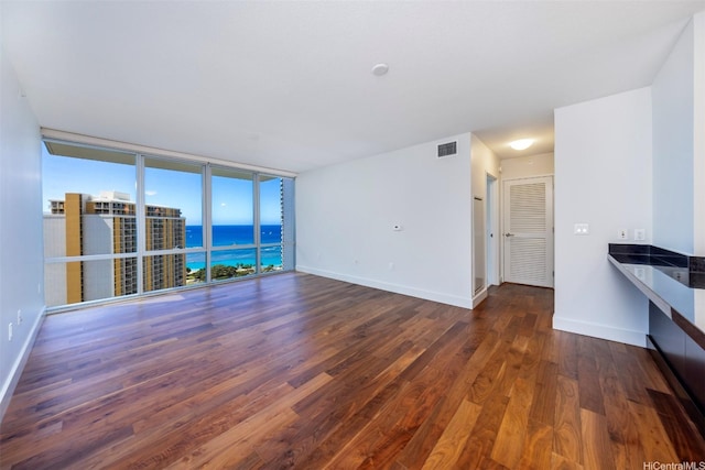 1189 Waimanu St Unit 2803, Honolulu, HI 96814 - unfurnished living room with wood finished floors, a water view, baseboards, and floor to ceiling windows