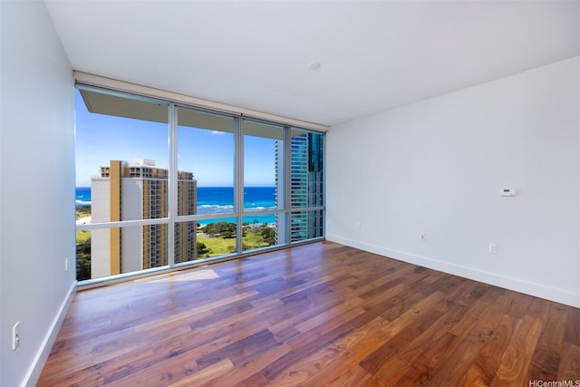 1189 Waimanu St Unit 2803, Honolulu, HI 96814 - unfurnished room featuring a water view, wood finished floors, baseboards, and expansive windows