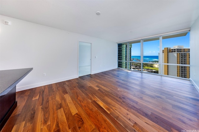 1189 Waimanu St Unit 2803, Honolulu, HI 96814 - empty room with baseboards, expansive windows, wood finished floors, and a water view