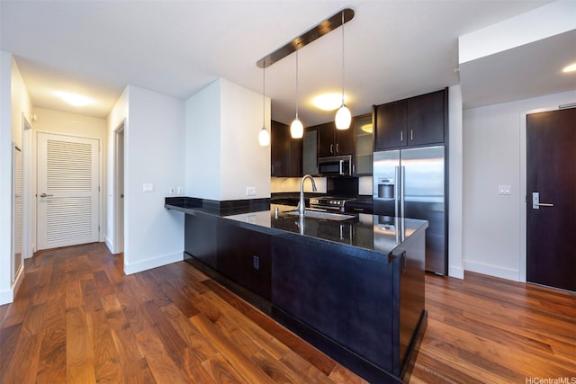 1189 Waimanu St Unit 2803, Honolulu, HI 96814 - kitchen with stainless steel appliances, a sink, baseboards, a peninsula, and dark brown cabinets