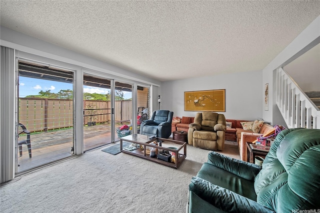 carpeted living area with a textured ceiling and stairway