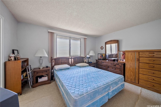 bedroom featuring light carpet and a textured ceiling