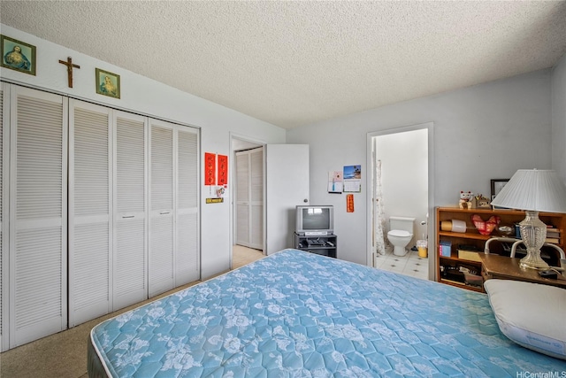 bedroom with a textured ceiling and ensuite bath