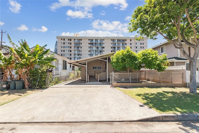 view of property featuring concrete driveway and fence