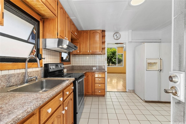 kitchen featuring stainless steel electric range, a sink, under cabinet range hood, white fridge with ice dispenser, and decorative backsplash