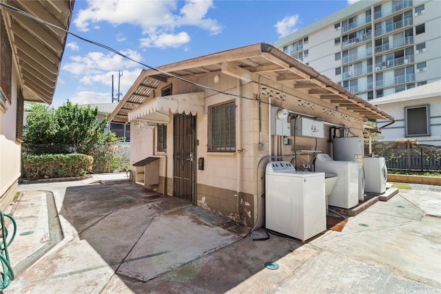 view of patio / terrace with washer / clothes dryer and fence