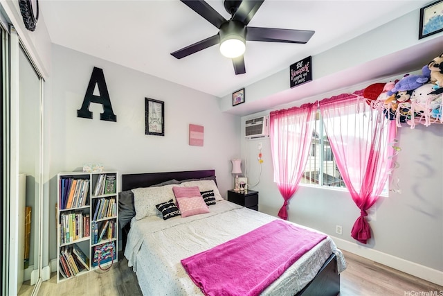 bedroom with a ceiling fan, baseboards, wood finished floors, and a closet