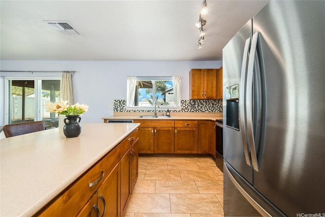 87-1801 Mokila St, Waianae, HI 96792 - kitchen with brown cabinets, a sink, stainless steel fridge with ice dispenser, light countertops, and visible vents