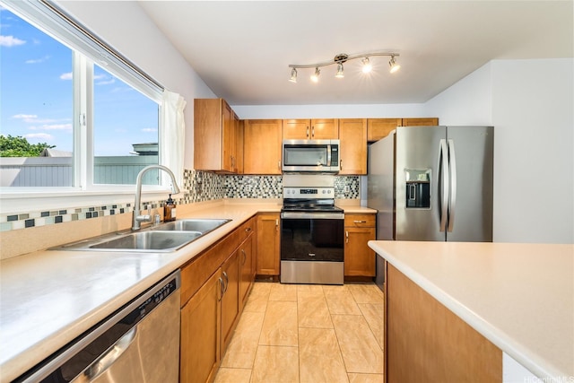87-1801 Mokila St, Waianae, HI 96792 - kitchen with appliances with stainless steel finishes, a sink, light countertops, brown cabinetry, and decorative backsplash