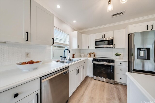 91-1180 Waiemi St, Ewa Beach, HI 96706 - kitchen featuring appliances with stainless steel finishes, a sink, white cabinetry, ornamental molding, and backsplash