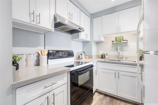876 Curtis St Unit 3208, Honolulu, HI 96813 - kitchen with under cabinet range hood, black electric range, white cabinetry, and freestanding refrigerator
