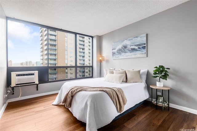 876 Curtis St Unit 3208, Honolulu, HI 96813 - bedroom featuring an AC wall unit, wood finished floors, a textured ceiling, and a view of city