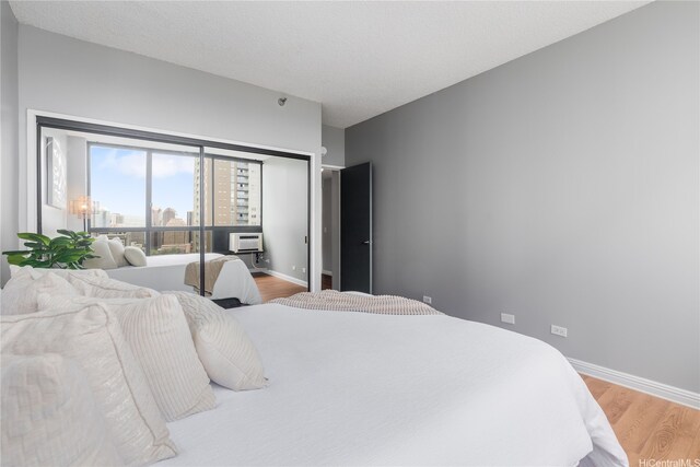 876 Curtis St Unit 3208, Honolulu, HI 96813 - bedroom with light wood-style floors and a wall unit AC