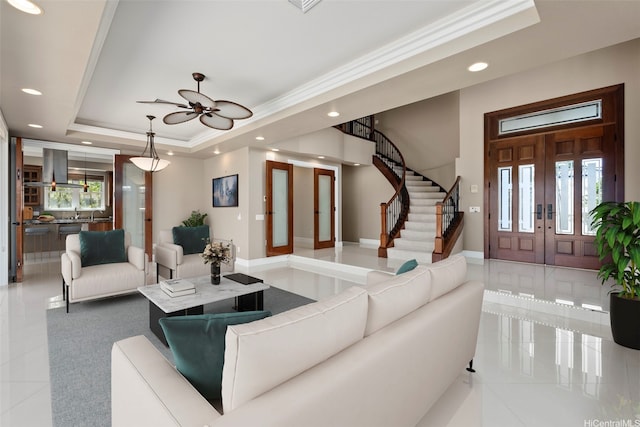 tiled living area featuring recessed lighting, a raised ceiling, crown molding, stairs, and ceiling fan