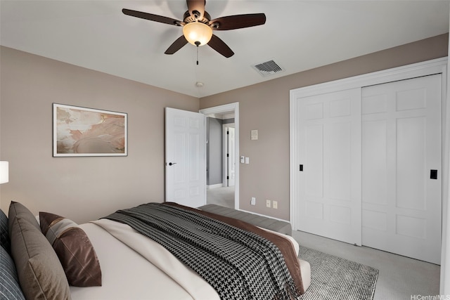 carpeted bedroom featuring a closet, baseboards, a ceiling fan, and visible vents
