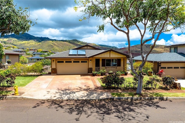 92-1199 Pueonani St, Kapolei, HI 96707 - view of front facade with a garage, a mountain view, solar panels, concrete driveway, and roof with shingles