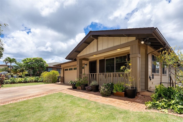 92-1199 Pueonani St, Kapolei, HI 96707 - craftsman-style house with a garage, concrete driveway, a porch, a front lawn, and board and batten siding
