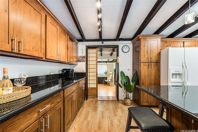 95-207 Waipono St, Mililani, HI 96789 - kitchen with dark stone countertops, brown cabinetry, white fridge with ice dispenser, light wood-type flooring, and beam ceiling