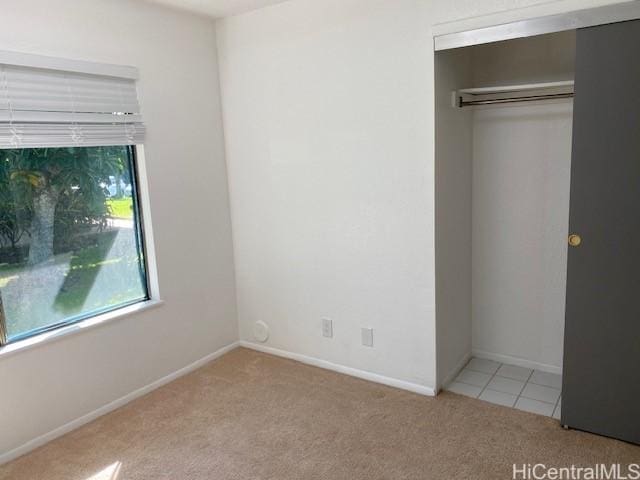 unfurnished bedroom featuring carpet and baseboards