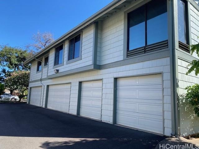 view of property exterior featuring aphalt driveway and a garage
