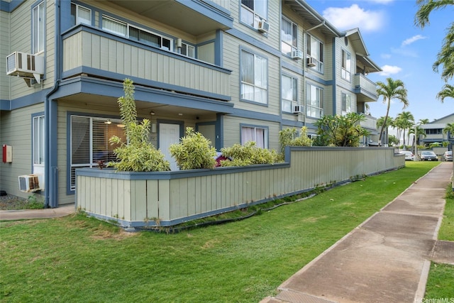 view of property exterior with a balcony, a yard, and a residential view
