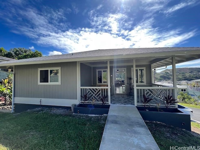 exterior space featuring covered porch and a front yard