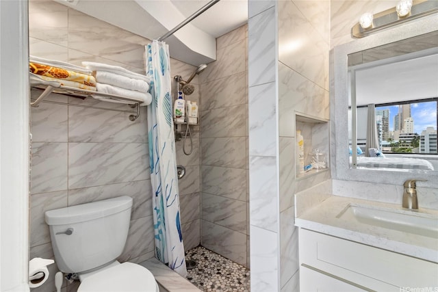 full bath with a shower stall, a view of city, vanity, tile walls, and toilet