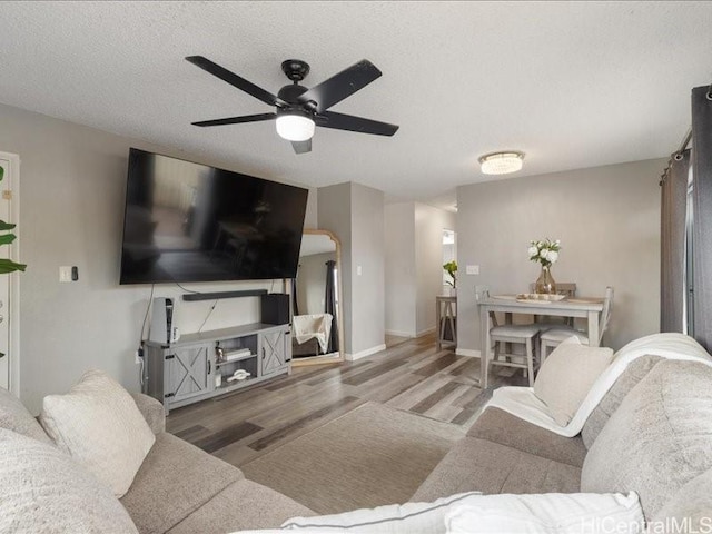 94-546 Kupuohi St Unit 104, Waipahu, HI 96797 - living area featuring baseboards, a ceiling fan, arched walkways, and wood finished floors
