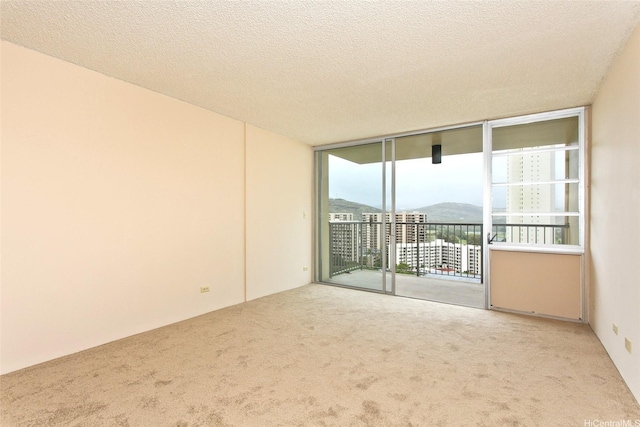3161 Ala Ilima St Unit 1515, Honolulu, HI 96818 - unfurnished room with a wall of windows, a textured ceiling, and carpet flooring