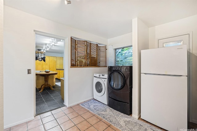 2168 Round Top Dr, Honolulu, HI 96822 - clothes washing area featuring light tile patterned floors, washer and dryer, laundry area, and baseboards