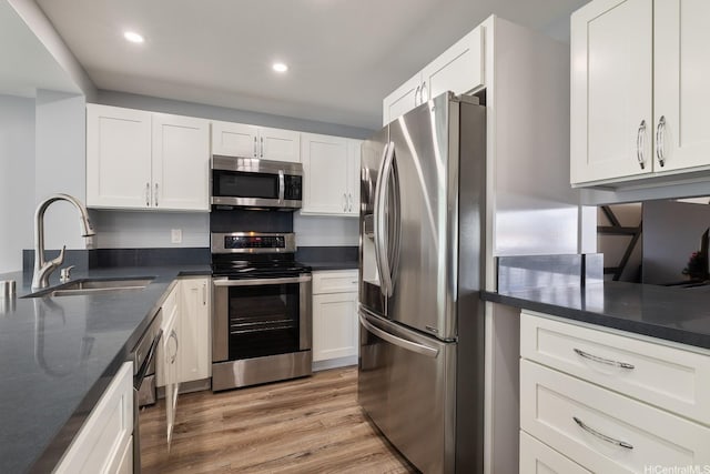 914 Lemiwai St, Wahiawa, HI 96786 - kitchen with appliances with stainless steel finishes, light wood-style floors, white cabinetry, recessed lighting, and dark stone counters