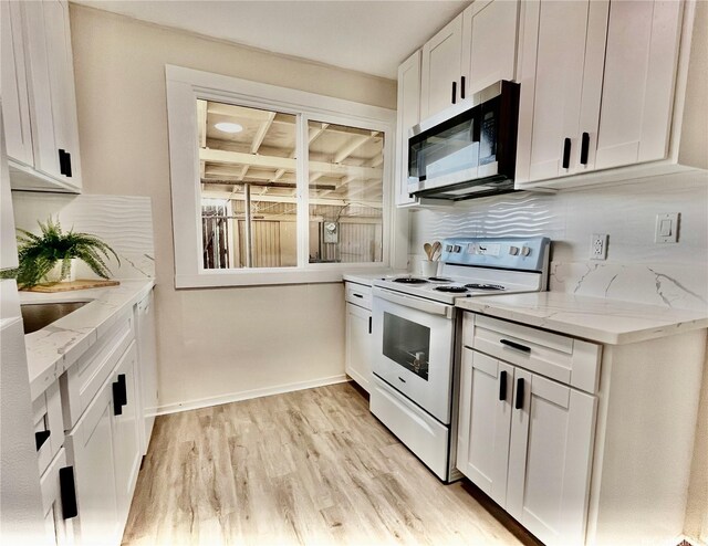 85-114 Ala Walua St Unit F, Waianae, HI 96792 - kitchen with stainless steel microwave, white electric stove, white cabinets, light wood-style flooring, and light stone countertops