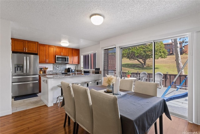 92-1327 Panana St Unit 49, Kapolei, HI 96707 - dining area featuring light wood-type flooring and a textured ceiling
