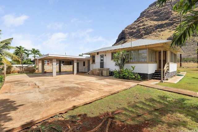 view of front of house featuring driveway, a front lawn, and a carport