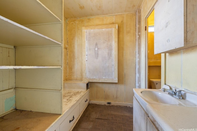 bathroom featuring toilet, wood ceiling, and a sink